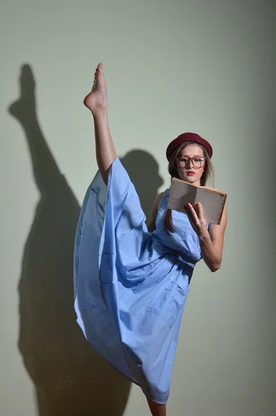 Gymnast in a red hat and glasses reading a book