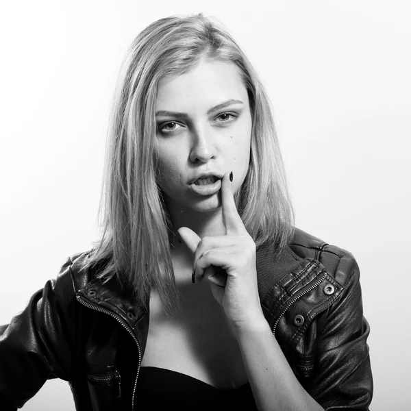 Sexy young blonde woman posing emotionally showing silence and looking at camera over light copy space background, black and white picture