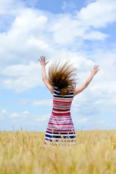 Image of one young pretty lady having fun standing in the field hands up on blue sky background copy space