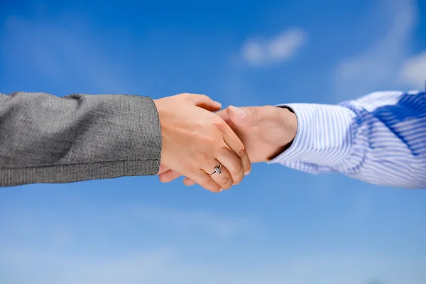 Close-up picture of business people handshaking on sunny day outdoors background
