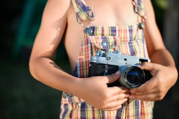 Closeup of vintage camera which is holding by child hands