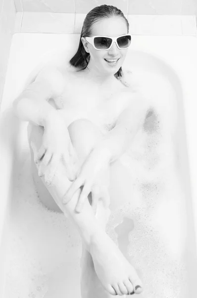 Picture of amazing beautiful sexy lady in sunglasses using luxury spa bath for relaxation. Black and white image