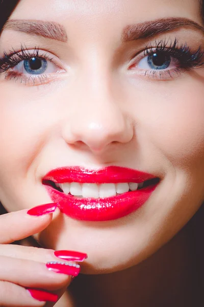 Attractive girl, tempting beuatiful young woman with blue eyes, long lashes, red lipstick and manicured nails
