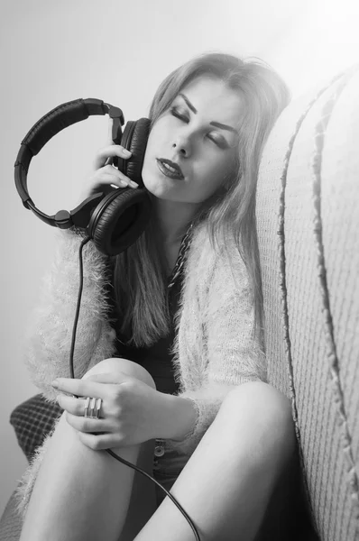 Picture of sexy pretty young lady having fun enjoying music from headphones. Black and white photography
