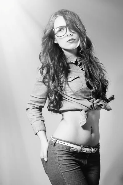 Black and white photography portrait of young trendy pretty lady wearing hipster glasses