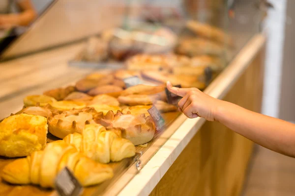 Childs hand with index finger pointing on some fresh pastry