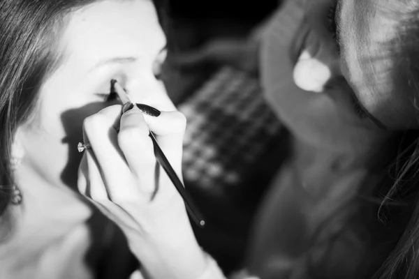 Picture closeup on makeup procedure. Black and white photography