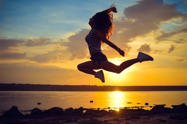 Image of beautiful young lady having fun jumping high over open water on summer outdoors copy space background