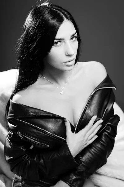 Sexy pretty young lady wearing leather jacket sensually looking at camera. Black and white photography