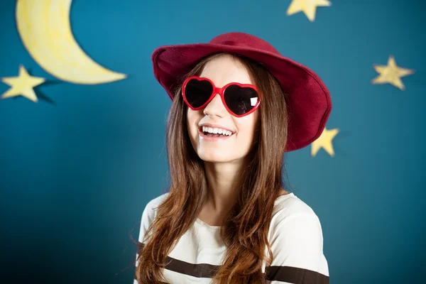 Pretty girl in red sunglasses with paper moon and stars