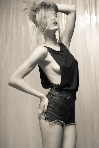 Black and white portrait of sexy beautiful young lady in black top and jeans shorts