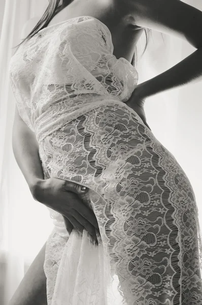 Sexy model wearing white dress, closeup on hips. Black and white photography