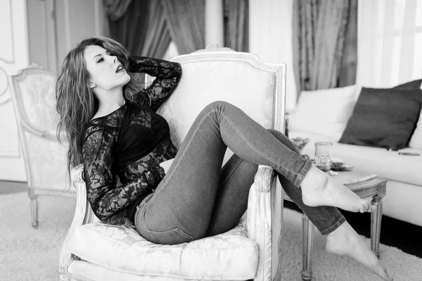 Black and white photography of beautiful young lady relaxing in chair