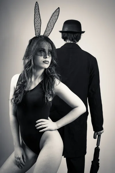Black and white photography of sexy beautiful young lady wearing bunny ears posing over male silhouette