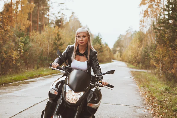 Biker girl rides a motorcycle in the rain. First-person view
