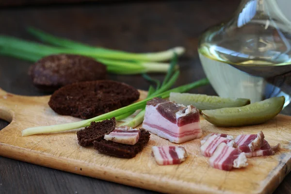Russian snack - salty bacon (salo) and vodka with rye bread and spring onions