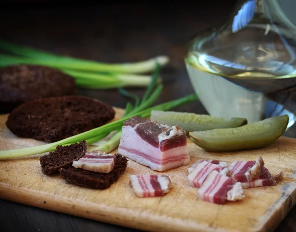Russian snack - salty bacon (salo) and vodka with rye bread and spring onions