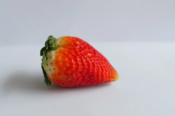 One strawberry from side with shadow isolated on white background