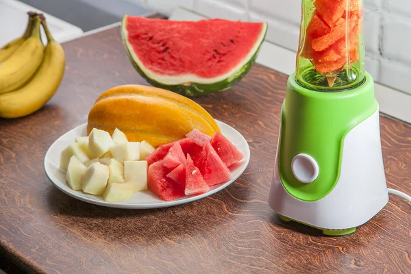 Blender with watermelon, melon and bananas