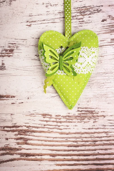 Green heart with butterfly on rustic grunge background