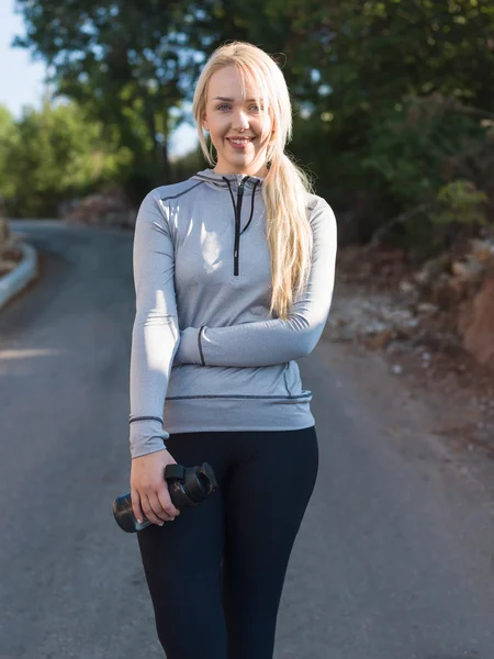 Portrait of a fitness woman doing warm up exercises outdoors