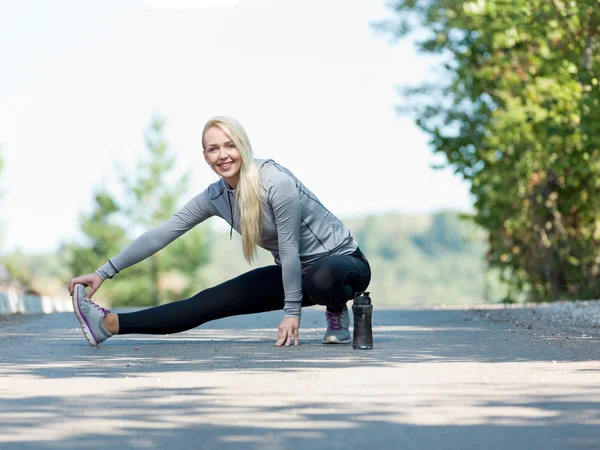 Fitness woman doing streching during outdoor cross training work