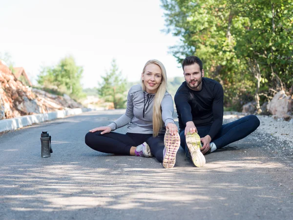 Young health couple doing stretching exercise relaxing and warm