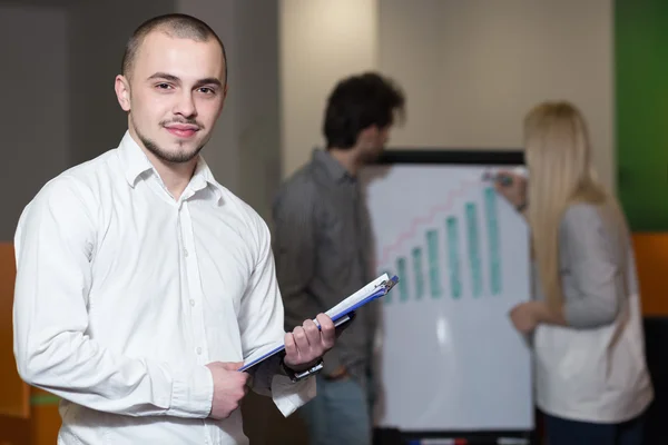 Group of friendly businesspeople with male leader in front