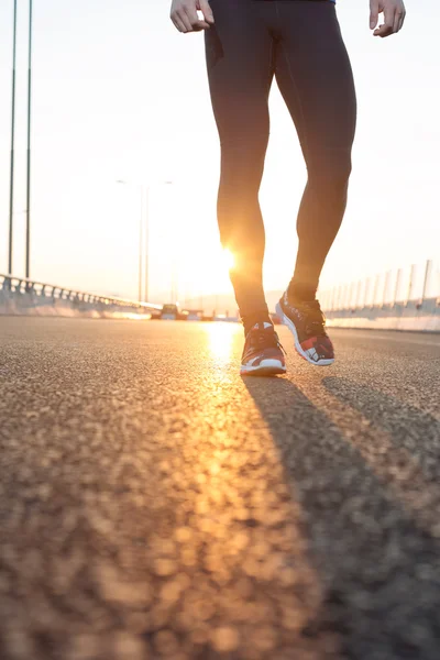 Feet of an athlete running on a park pathway training for fitnes