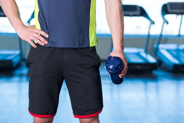 Closeup of man in gym with blue protein shaker