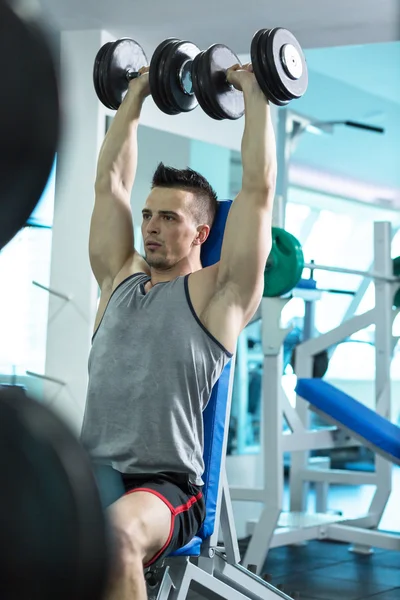 Muscular Young Man Doing Heavy Weight Exercise For Biceps With D