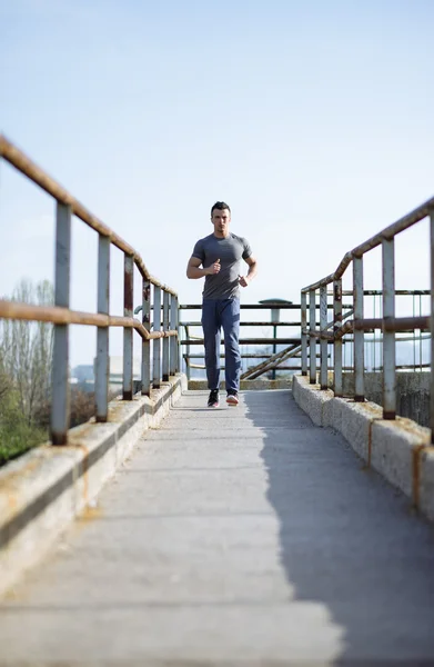 Moving to his goal. Side view of confident young man running alo