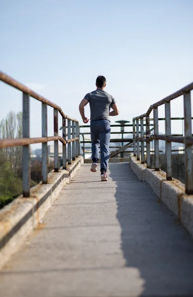 Moving to his goal. Side view of confident young man running alo