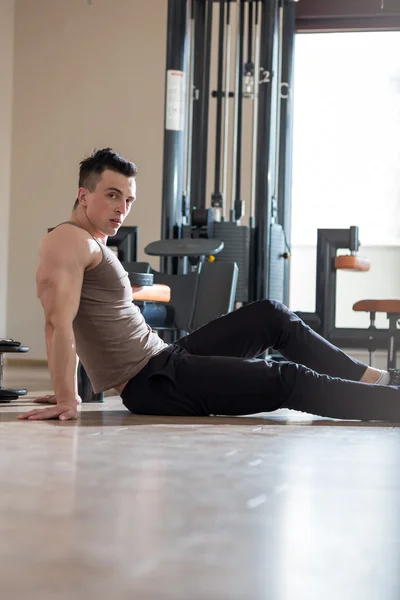 Stretching after great work out. Young handsome man in sportswea