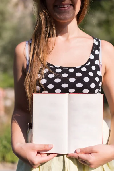 Woman holding open book in nature