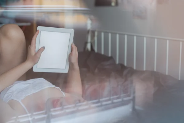 Woman using tablet in bed