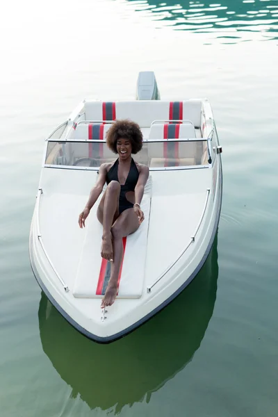 Afro woman relaxing on speedboat