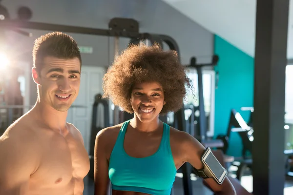 Man and woman posing in gym
