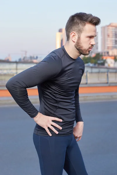 Muscular build handsome athlete resting after a morning run