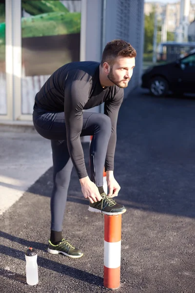 Running and jogging exercising concept. Man tying laces