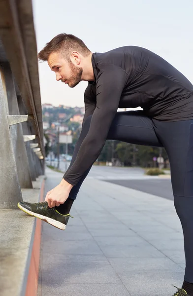 Running and jogging exercising concept. Man tying laces before t