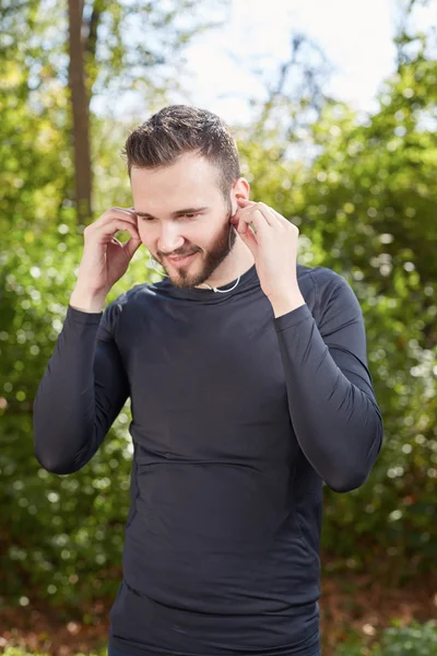 Handsome sporty man  tired runner resting after evening jog, fit