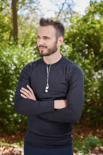 Handsome sporty man  tired runner resting after evening jog, fit