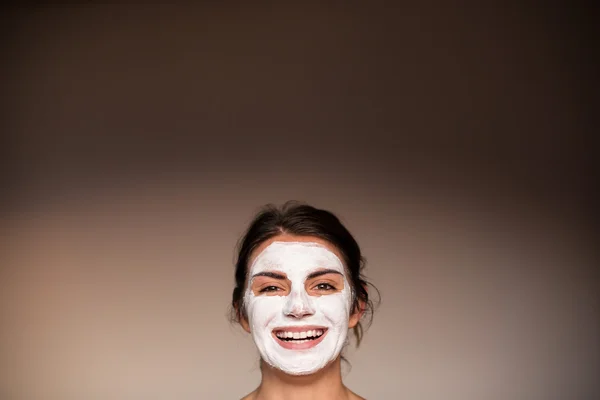 Young emotional woman with facial mask