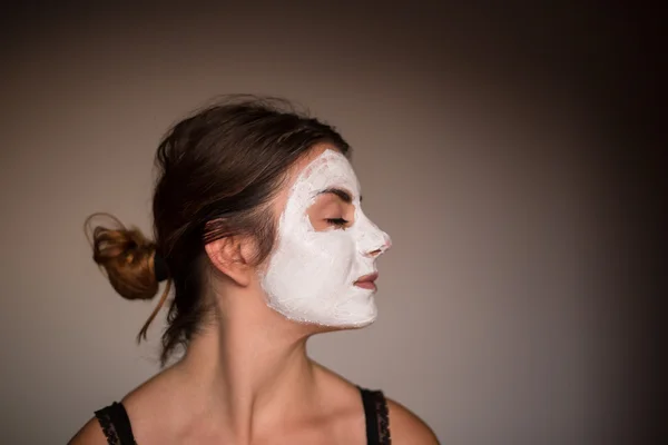 Young emotional woman with facial mask
