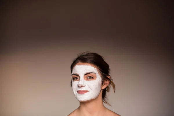 Young emotional woman with facial mask