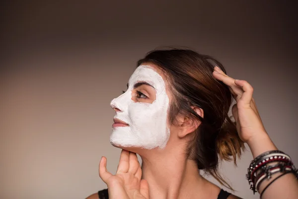 Young emotional woman with facial mask