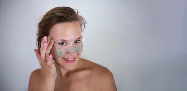 Young emotional woman with facial mask