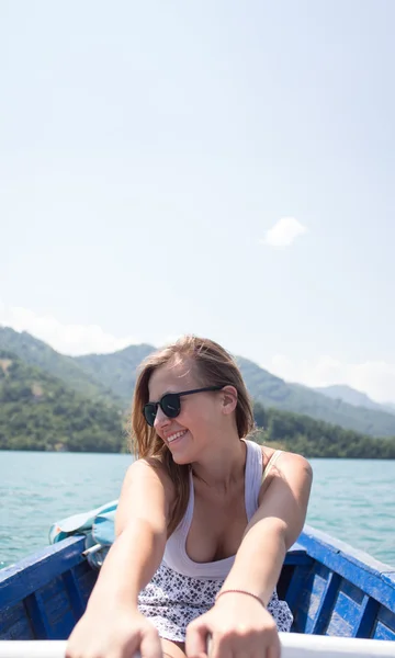 A young woman is rowing a boat on a summer day