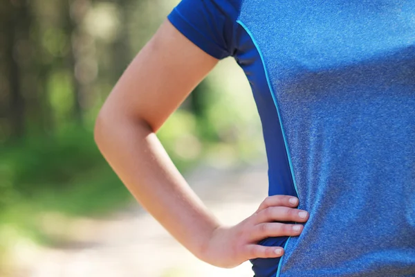Cropped shot of fit woman in sports wear standing with her hand
